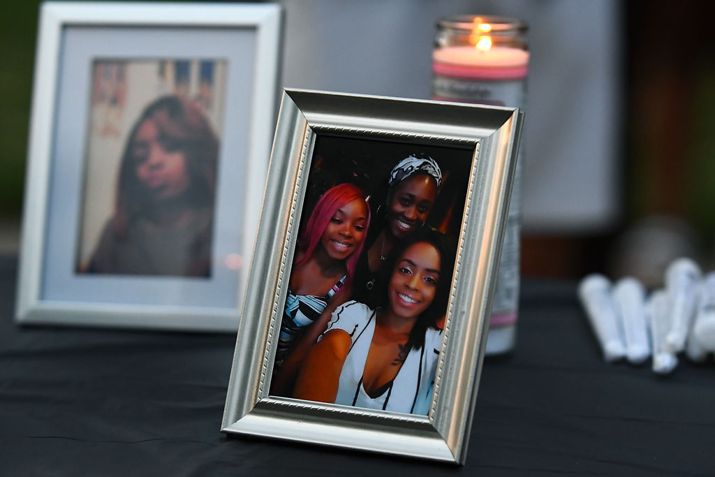 Photos of Nadria Wright sit on a table at a vigil in her honor